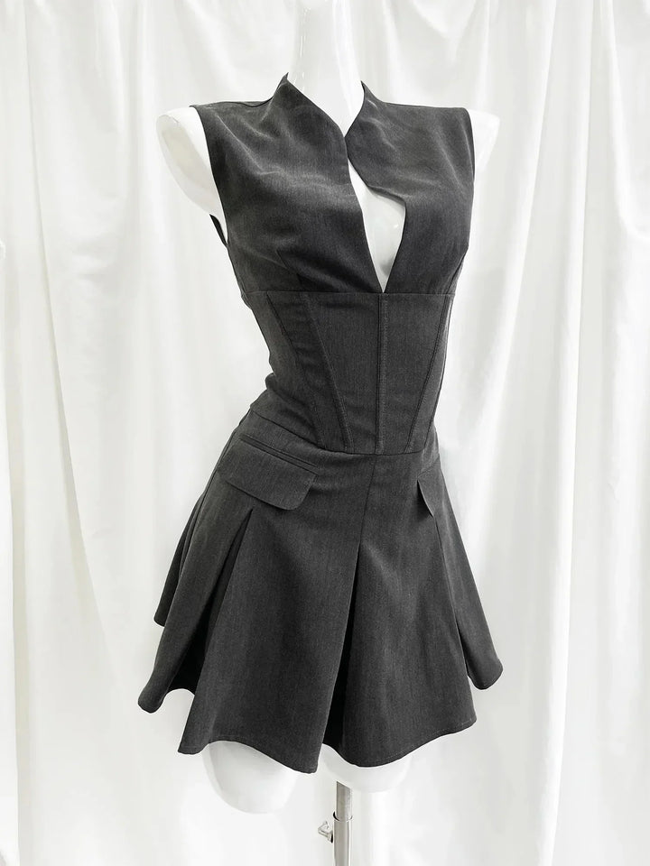 Black sleeveless dress on a mannequin against a white curtain background