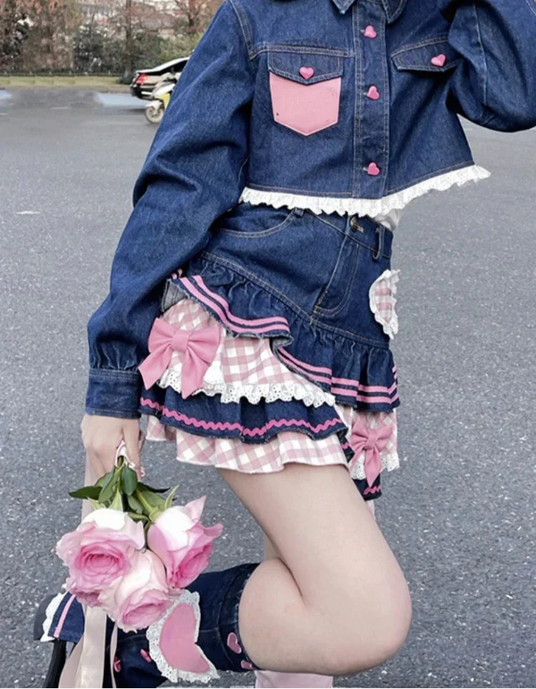 Person wearing a denim outfit with pink accents, holding flowers on a street.